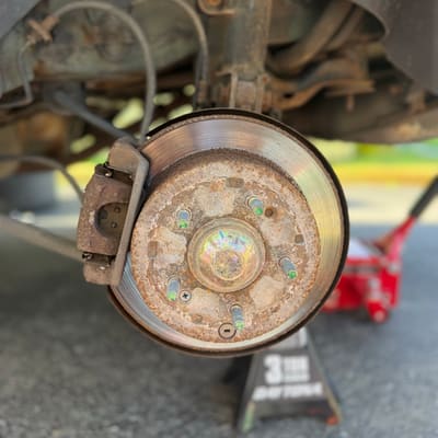 Brake rotor so corroded the face has turned to orange scale, the car up on a jack stand