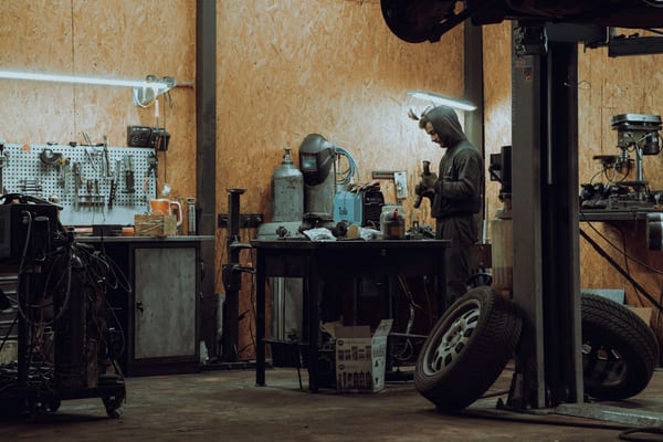 Working bay of an auto garage with a wheel off and tools on the bench