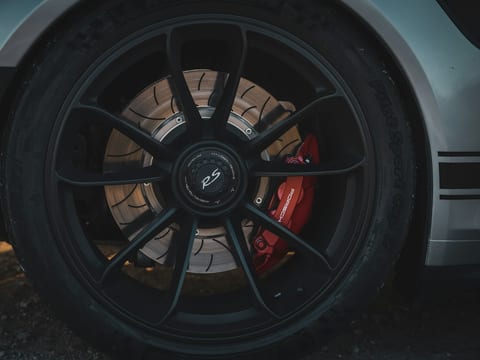 Red brake caliper visible behind the spokes of a black alloy wheel